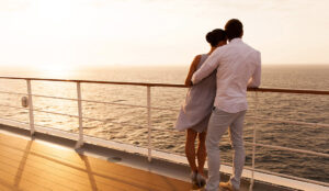 young couple hugging at sunset on cruise ship