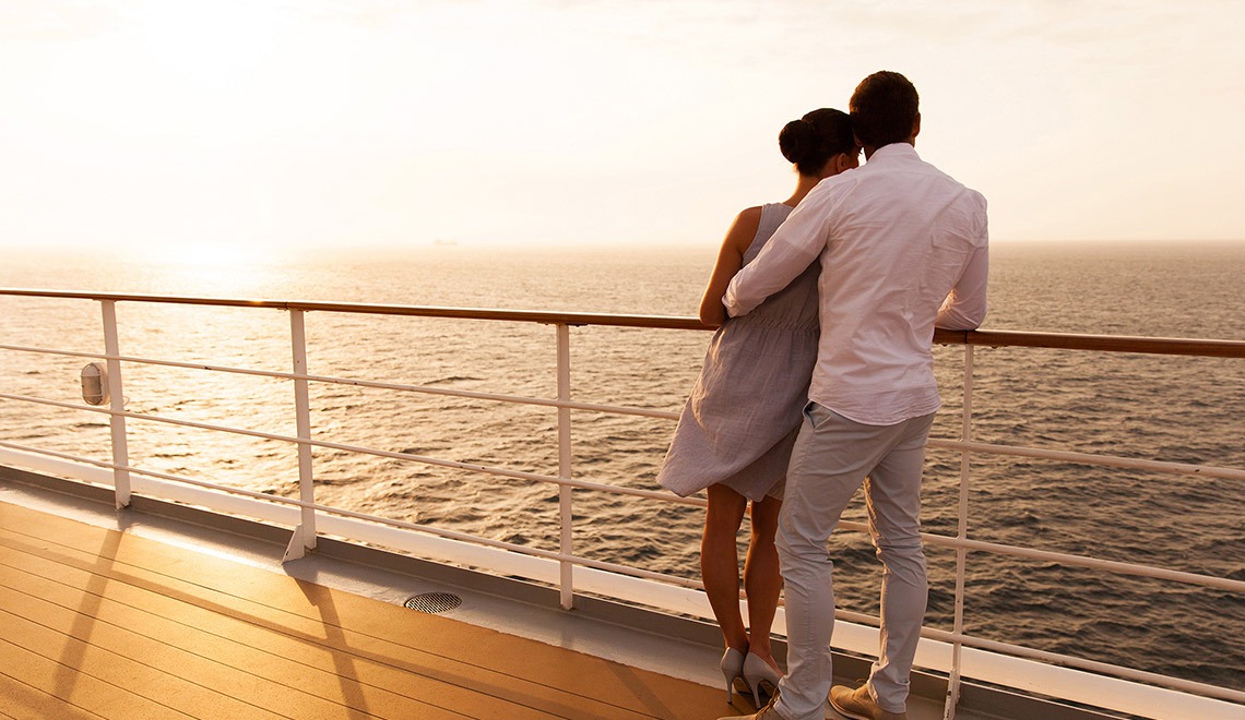 young couple hugging at sunset on cruise ship