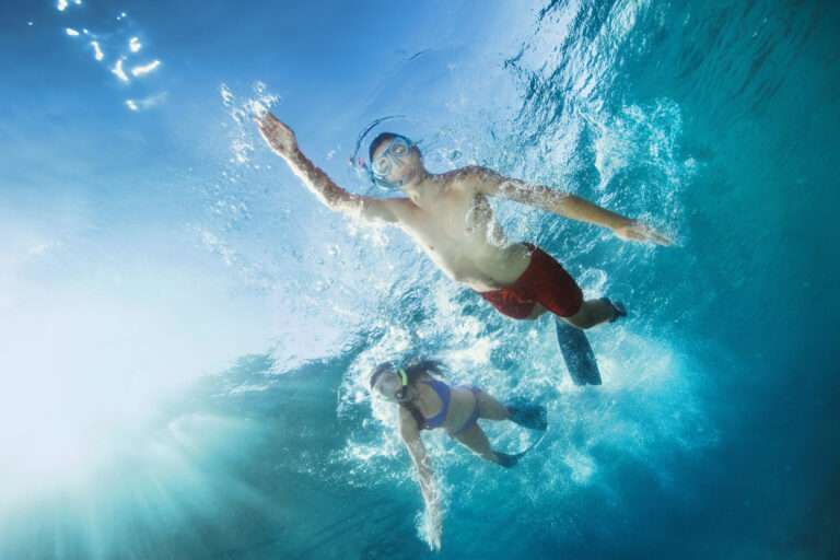 Young man and woman snorkeling Underwater diving adventure Turquoise sea